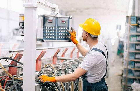 Machine operator with safety helmet working