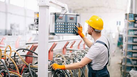 Machine operator with safety helmet working