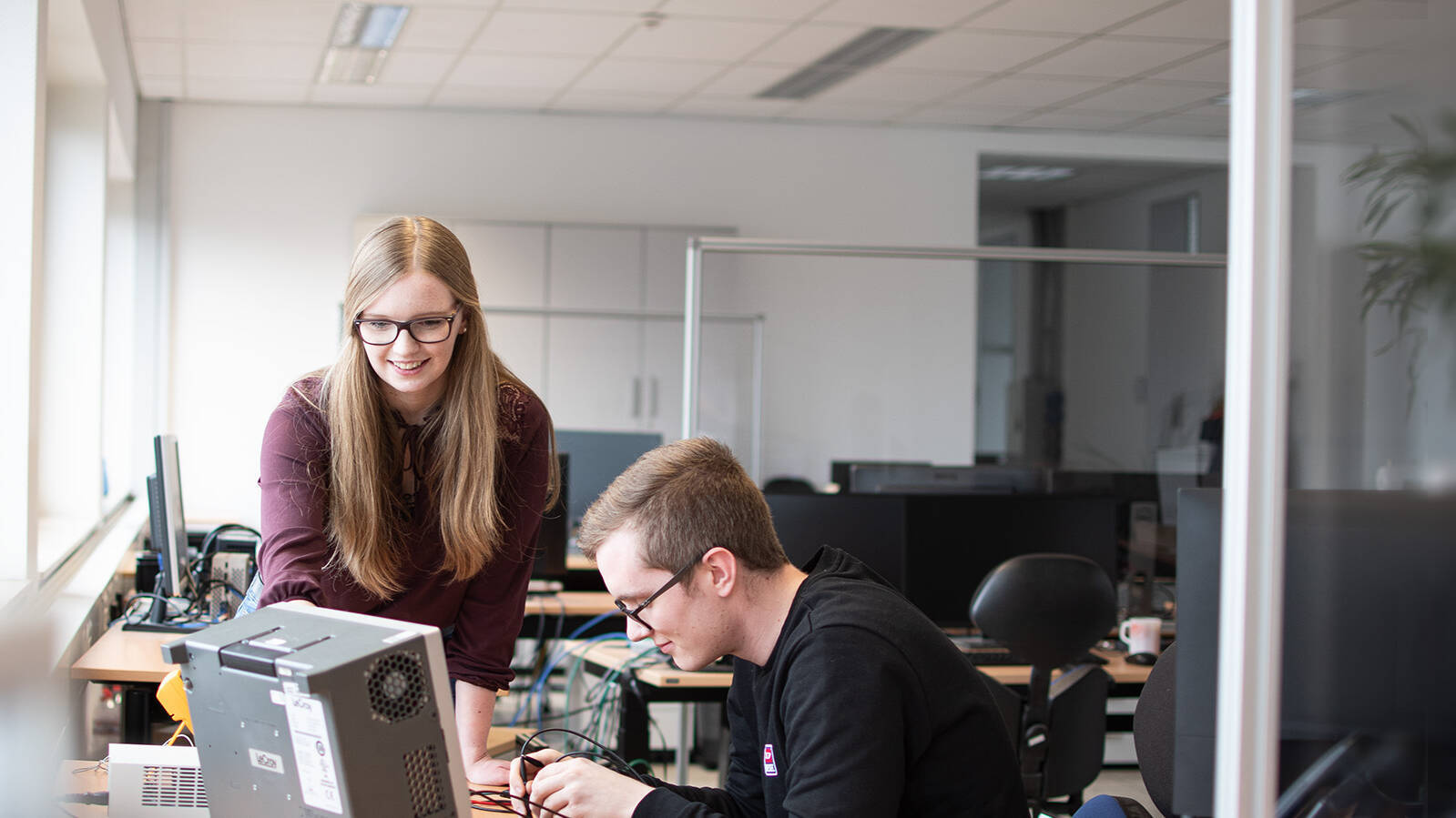 A woman and a man soldering at their desk