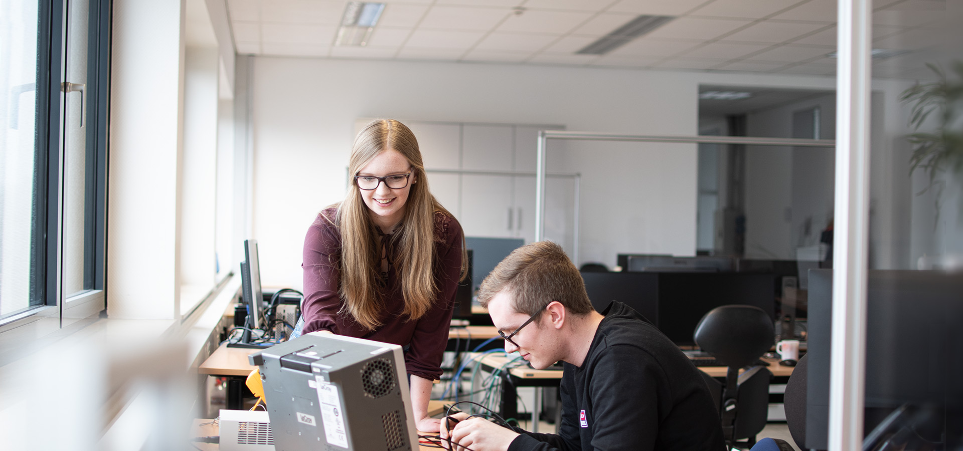 A woman and a man soldering at their desk